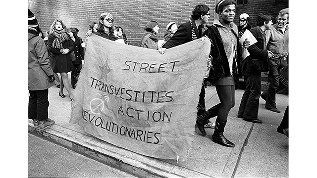 Photograph of Members of the Street Transvestite Action Revolutionaries protesting holding sign that reads, Street Transvestite Action Revolutionaries
