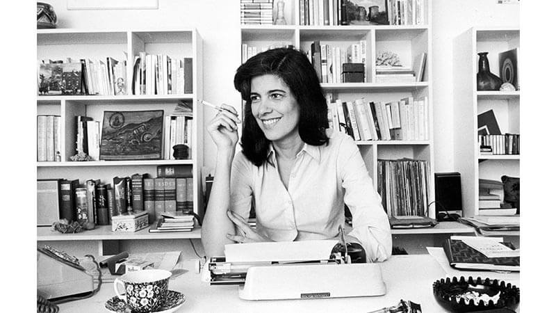 Black and white image of writer Susan Sontag at a typewriter