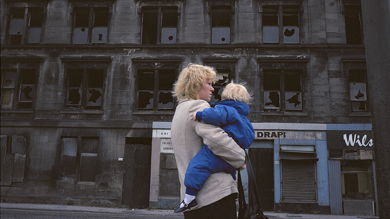 Image of a woman with a child in front of a derelict building in Glasgow