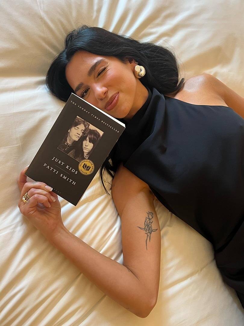 Dua Lipa holding Service95 Book Club's September Monthly Read Just Kids Patti Smith