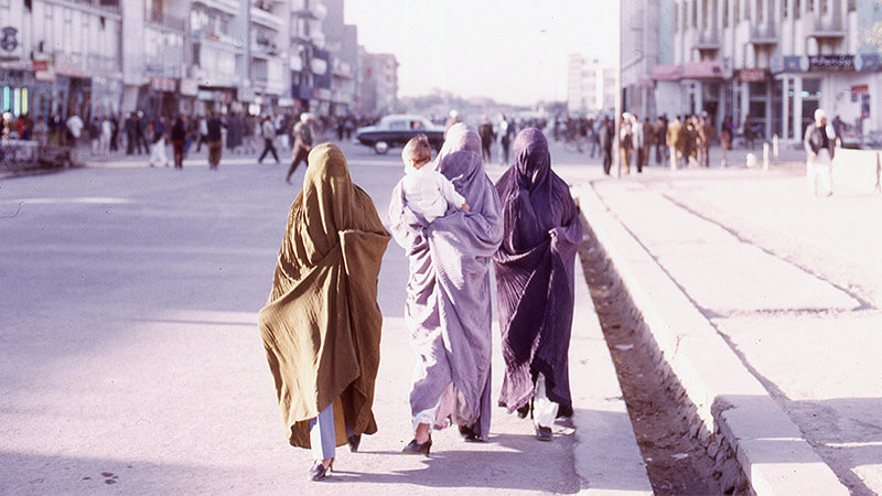 Women walking down street in Kabul city, Afghanistan in 1973, wearing full length Burqas