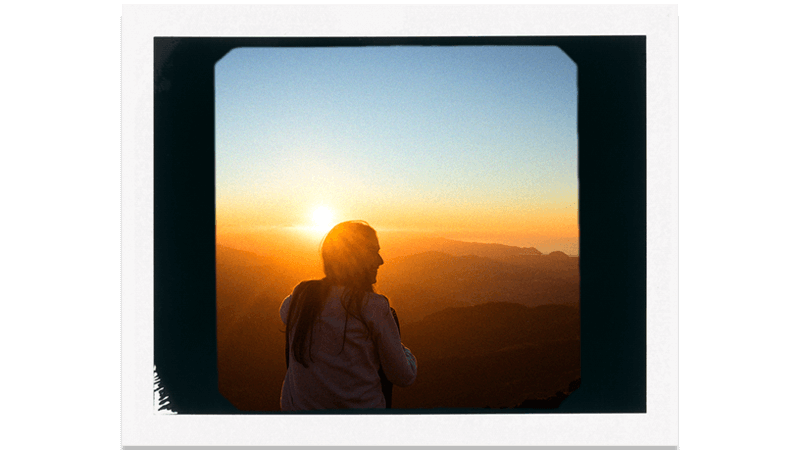 Girl watching sun rise from Mountain range