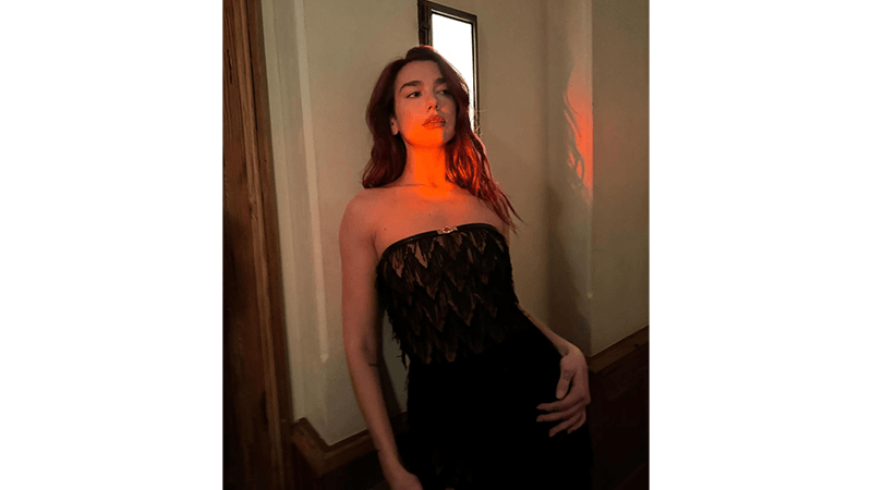 Dua Lipa with red hue sunlight on face