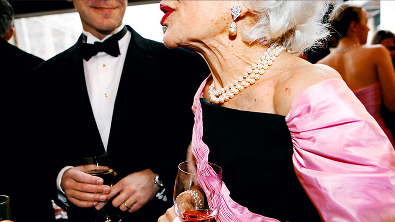 Image of mature woman gossiping at a party
